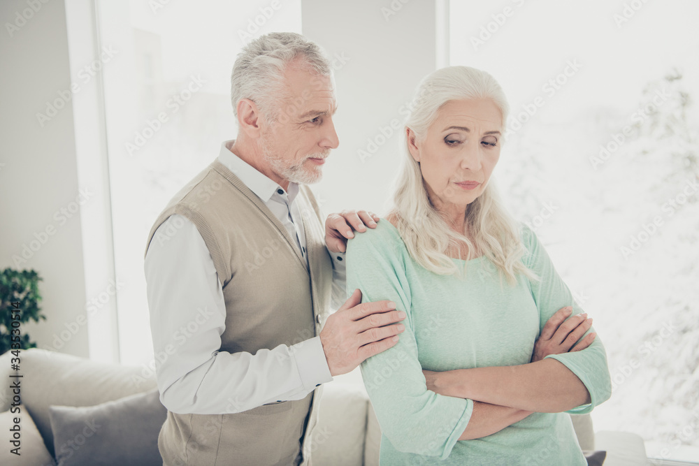 Close-up photo of happy smiling optimistic husband trying to calm down his jealous lady Close-up photo of happy smiling optimistic husband trying to calm down his jealous lady