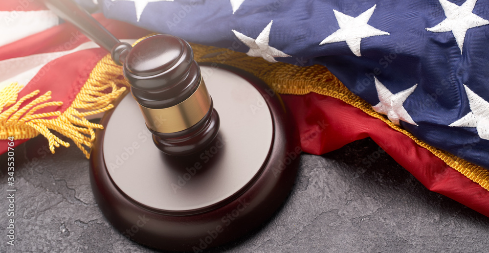 Top view of wooden gavel on background of American flag on black background