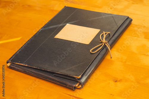 Vintage folder for paper with blank label. old folder for documents lies on a wooden table