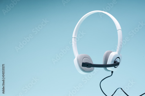 Headphones with microphone on blank blue background