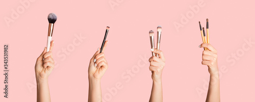 Various makeup brushes in female hands on pink background, closeup. Collage. Panorama