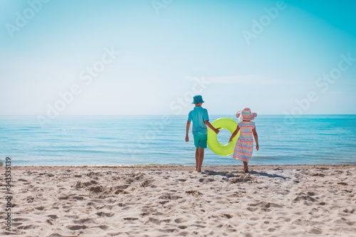 boy and girl with floatie go to beach
