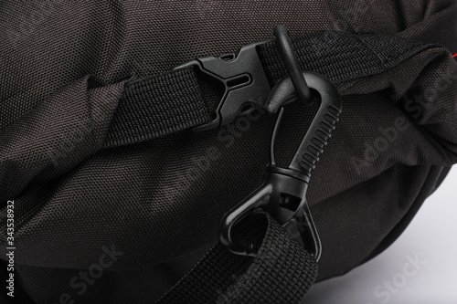 Black plastic locks on a black bag. Mount, carabiner, clasp.