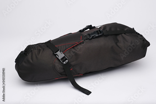 Modern bicycle fabric bag with frame or saddle mount. Black bag with red stitching. Isolated, white background.