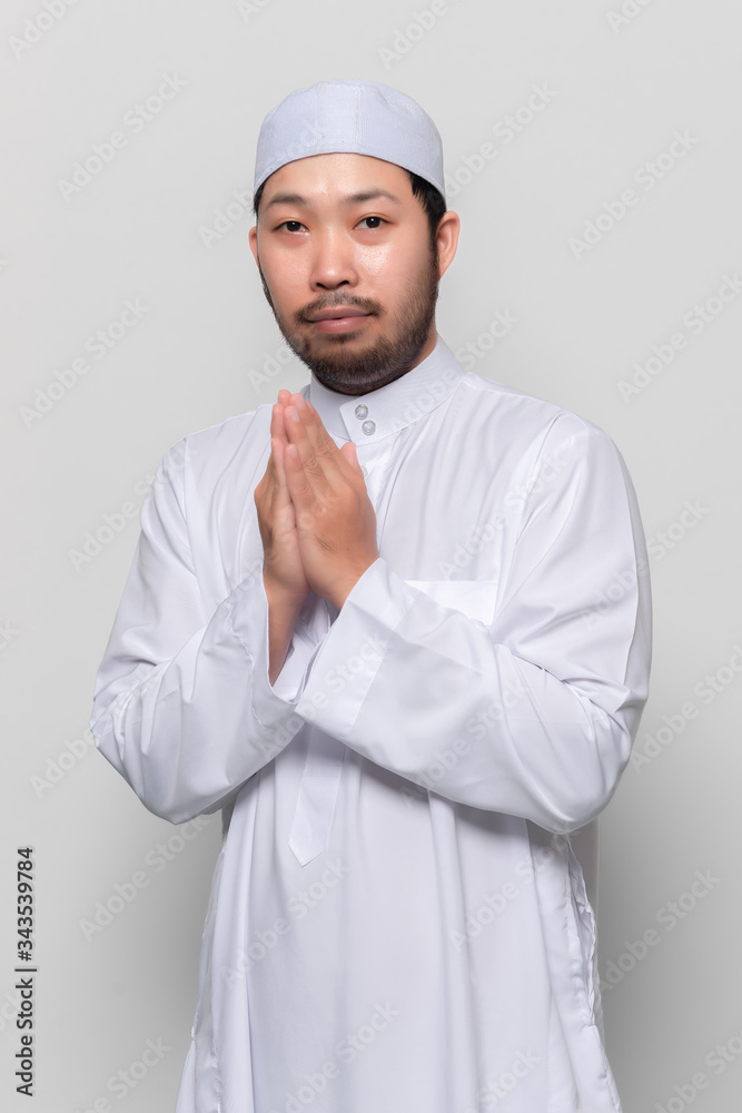 Portrait of smart handsome muslim man on white background,Greeting with respect to the Thai style Portrait of smart handsome muslim man on white background,Greeting with respect to the Thai style