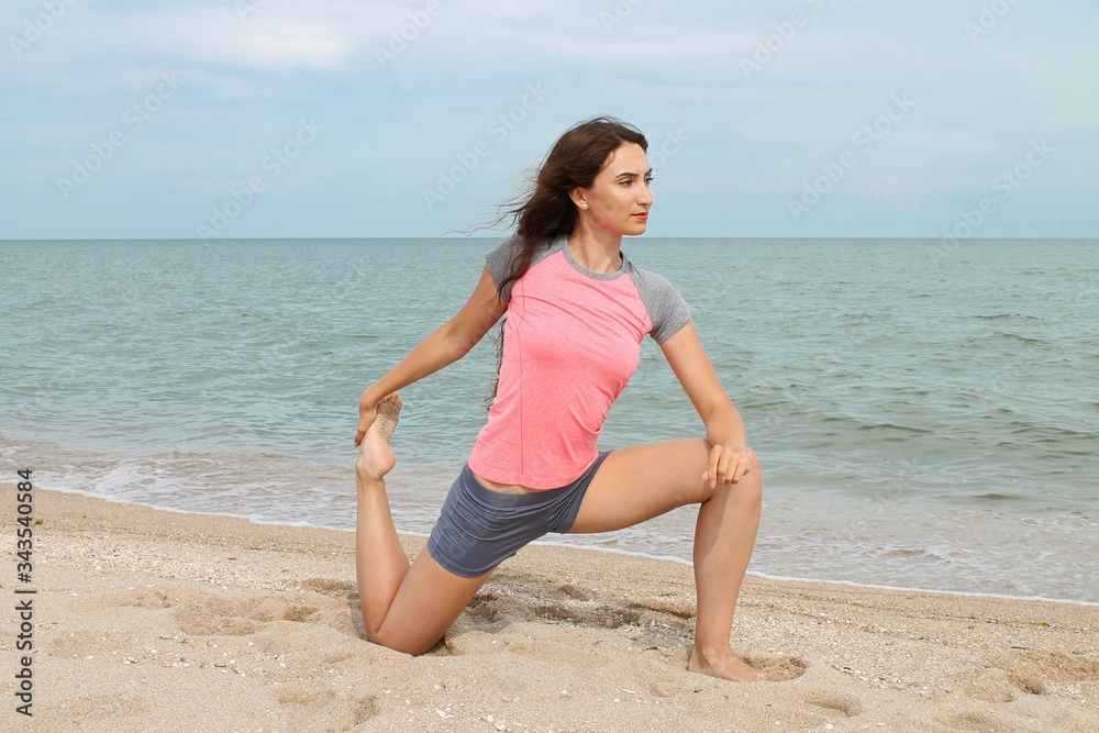 Young european woman practicing yoga in lotus position on the beach. Healthy active lifestyle concept. Quarantine is finish Young european woman practicing yoga in lotus position on the beach. Healthy active lifestyle concept. Quarantine is finish