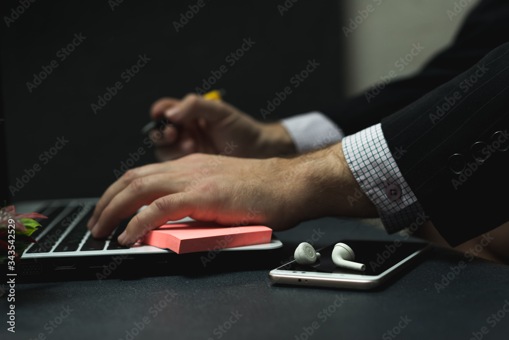 Remote work at home, close-up image of a young professional male manager with a laptop. Corona virus. Entrepreneur working at home using a laptop computer.