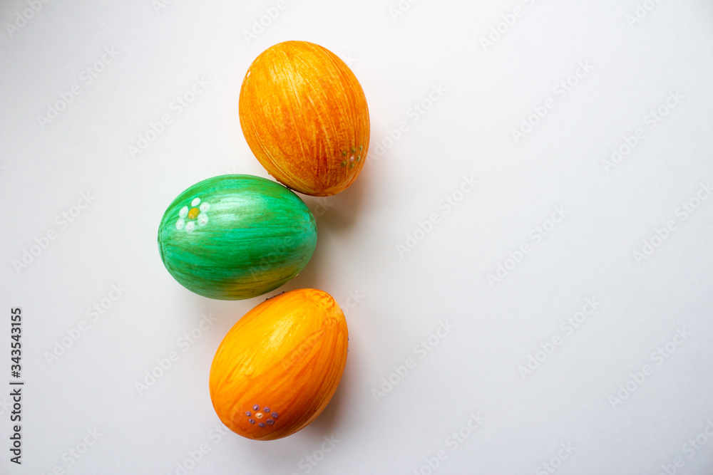 Green and orange eggs on a white background close-up Green and orange eggs on a white background close-up