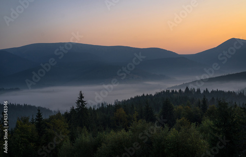 Smoky mountain landscape with mountain and light rays before sunrise.