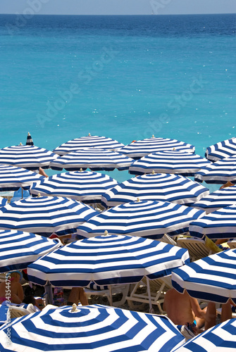 Sonnenschirme, blau-weiß gestreift, am Strand an der Côte d'Azur