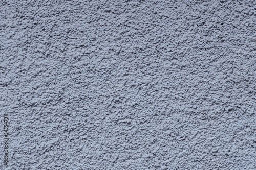 Eine Nahaufnahme einer graublauen Putzsteinfassade bildet einen planen Hhintergrund für eine grafische Gestaltung.