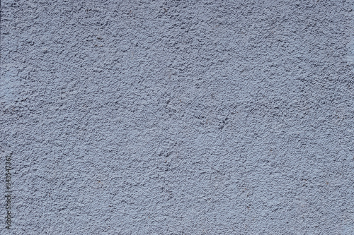 Ein Teilstück einer graublauen Putzsteinfassade bildet einen planen Hhintergrund für eine grafische Gestaltung.