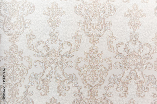 The texture of the Wallpaper. Beige and gold patterns in the form of monograms. Desktop background.