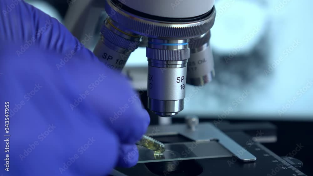 Scientist in laboratory working with microscope.