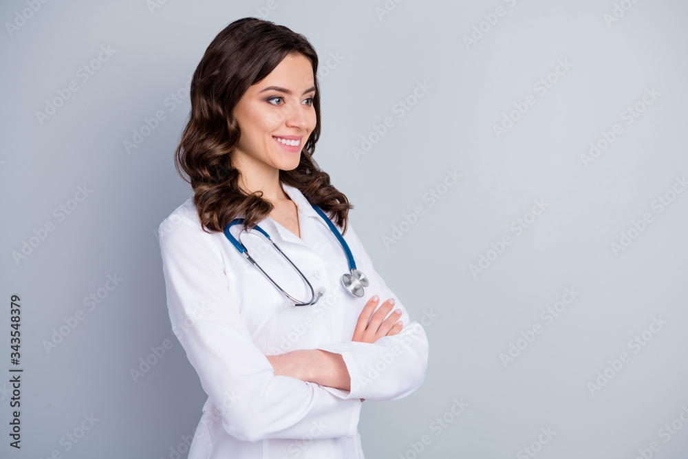 Profile photo of beautiful family doc lady patients consultation beaming smiling virology clinic arms crossed look empty space wear lab coat stethoscope isolated grey color background Profile photo of beautiful family doc lady patients consultation beaming smiling virology clinic arms crossed look empty space wear lab coat stethoscope isolated grey color background