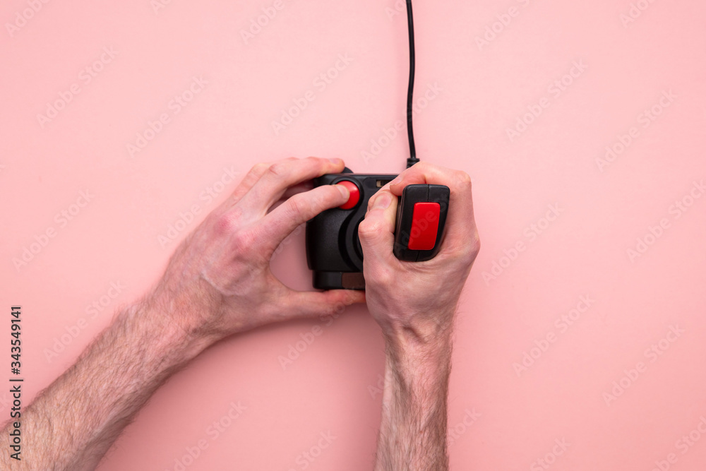 Fototapeta premium Male hand using retro video game joystick controller. Overhead view
