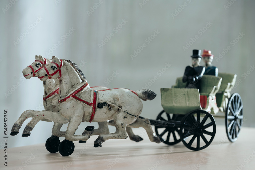 Vintage figurine - horses harnessed to a cart with a coachman and a passenger.