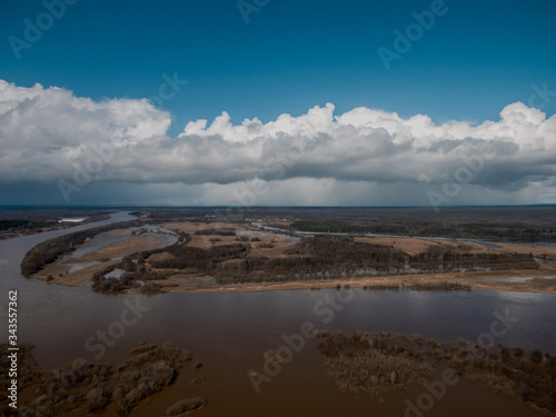 beautiful clouds float over the spilled river © Dmitrii