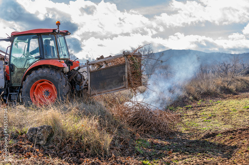 pruning of vineyards in spain and collection and burning of vine shoots by tractor