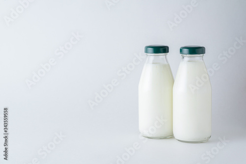 Two glass bottles of homemade kefir on a white background with copy space