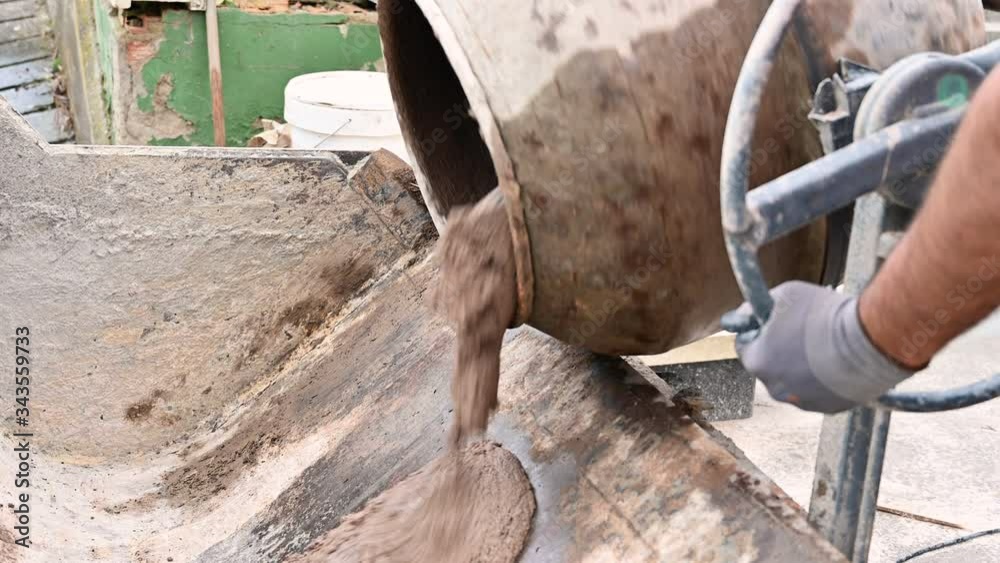 Concrete being poured out of the concrete mixer .