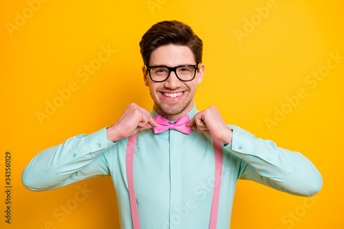 Portrait of attractive cheerful guy touch bow tie prepare for valentine day date wear stylish outfit isolated over vibrant bright color background