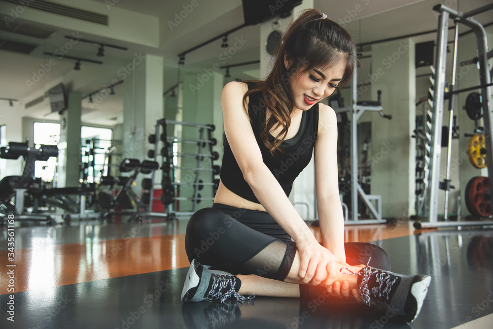 Asian woman injuries during workout at knee in fitness gym sport center. Medical and Healthcare concept. Exercise and Training theme. People healthy lifestyle and leisure activity problem Asian woman injuries during workout at knee in fitness gym sport center. Medical and Healthcare concept. Exercise and Training theme. People healthy lifestyle and leisure activity problem