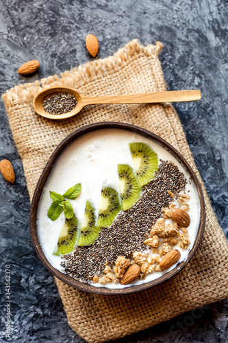 smoothie bowl with granola in a coconut bowl, top view. Healthy vegan food concept.