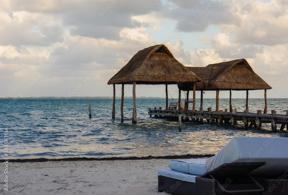 lounge chair on a beach with two palapas, traditional Mexican shelter with thatched roof of palm leaves
lounge chair on a beach with two palapas, traditional Mexican shelter with thatched roof of palm leaves