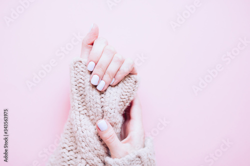 Stylish trendy nail young woman hands light blue manicure on pink background. Stylish trendy female manicure. Top view. Beautiful young woman s hands on pink background. Copy free space. 