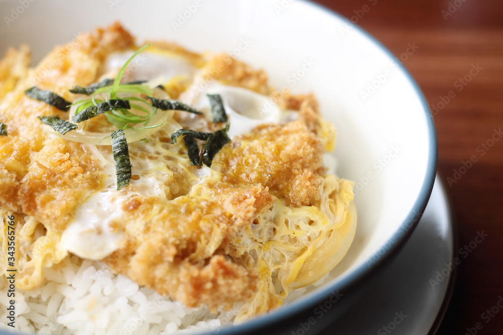 Katsudon is a popular Japanese food, a bowl of rice topped with a deep-fried chicken cutlet, egg, vegetables, and condiments Katsudon is a popular Japanese food, a bowl of rice topped with a deep-fried chicken cutlet, egg, vegetables, and condiments