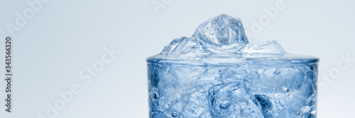 banner. Close-up of a glass cup filled with ice and water.