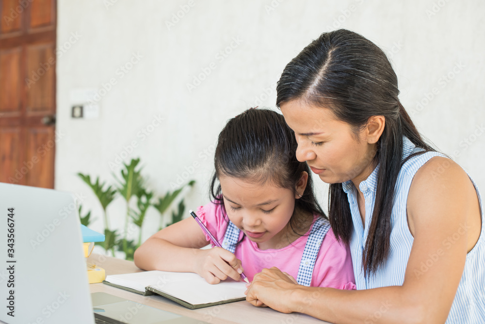 asia girl student online learning study online video call teacher. social distance during quarantine, self-isolation, online education concept, homeschool, cute girl with mother doing homework at home asia girl student online learning study online video call teacher. social distance during quarantine, self-isolation, online education concept, homeschool, cute girl with mother doing homework at home