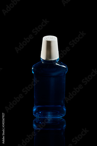 plastic bottle blue sanitizer. Black background