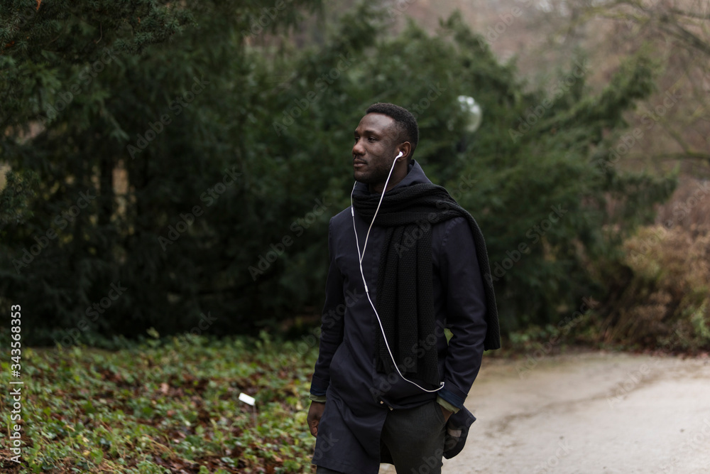 Side View of Handsome Black Man Walking in Park Side View of Handsome Black Man Walking in Park