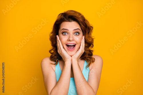 Closeup photo of pretty shocked lady open mouth see cool sale prices shopping advert arms on cheeks wear casual turquoise tank-top isolated bright yellow color background