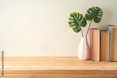 Books and plant on wooden table with copy space. Education background