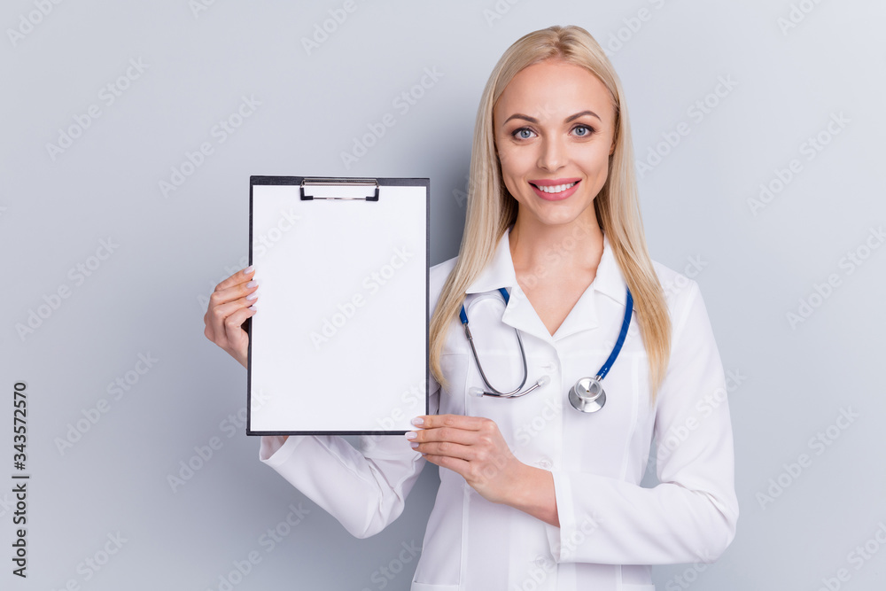 Close-up portrait of her she nice attractive lovely cheerful blonde girl medic expert human healthcare assistant showing blank copy space document isolated on grey pastel color background Close-up portrait of her she nice attractive lovely cheerful blonde girl medic expert human healthcare assistant showing blank copy space document isolated on grey pastel color background