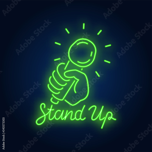 Stand up neon sign. Microphone in human hand on brick wall background. Night bright advertisement. Vector illustration in neon style for comedy show