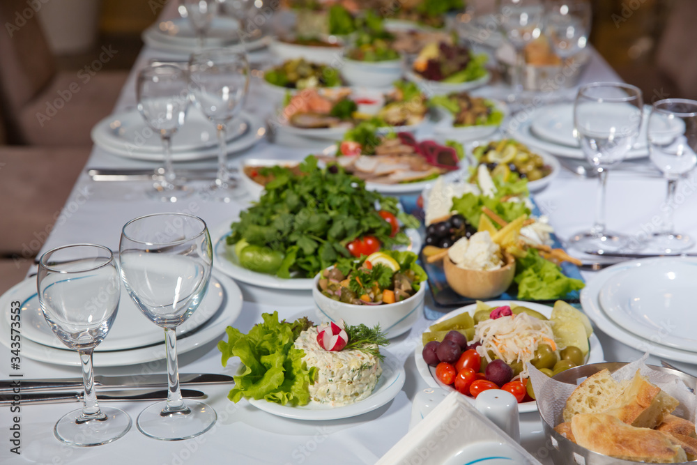 Set of a dish with spoon, fork and knife on white table.Table setting on white table . Served holiday table, cutlery, crockery, glasses, plate, fork. Salads and gums .