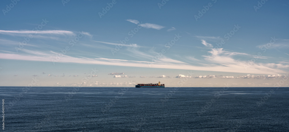 Container ship at sea. Wide banner, Bright summer sunny day, sea, blue water. Shipping cargo by sea. Logistic.