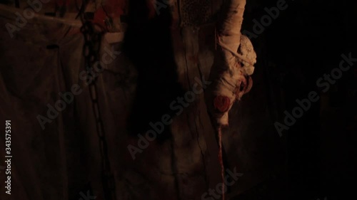 Silhouette of man maniac or killer or horror murderer with chainsaw in hand in dark creepy and spooky room. Criminal robber or rapist concept in thriller atmosphere with  victim girl