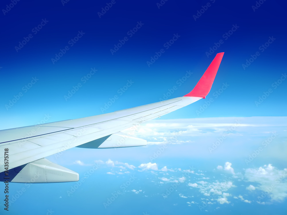 A wing of passenger plane, view from a porthole at high altitude A wing of passenger plane, view from a porthole at high altitude