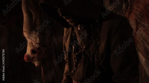 Silhouette of man maniac or killer or horror murderer with chainsaw in hand in dark creepy and spooky room. Criminal robber or rapist concept in thriller atmosphere with  victim girl