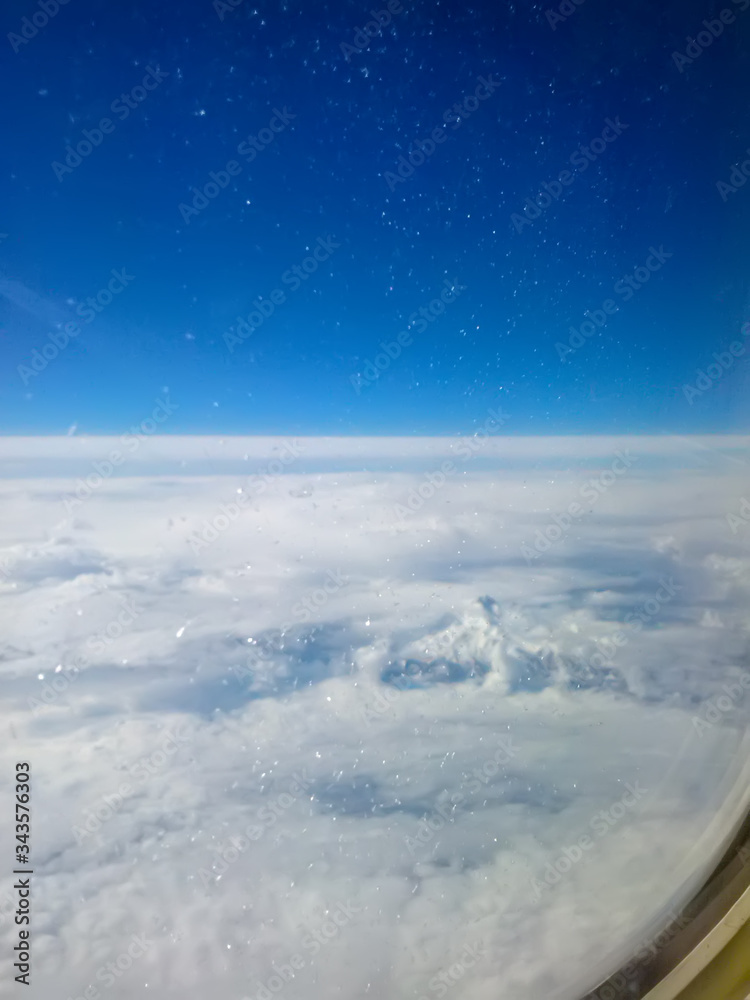Solid clouds during the flight. View from the window of the plane at high altitude