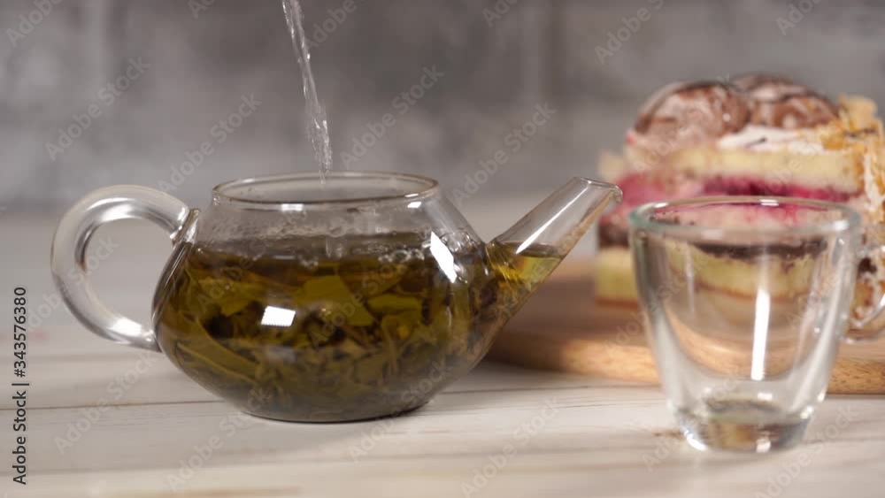 Close up of green tea in teapot and cup on white wooden table. Close up of green tea in teapot and cup on white wooden table.
