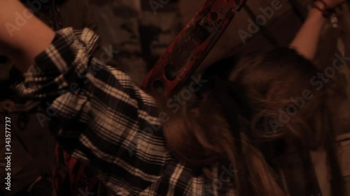 Silhouette of man maniac or killer or horror murderer with chainsaw in hand in dark creepy and spooky room. Criminal robber or rapist concept in thriller atmosphere with  victim girl