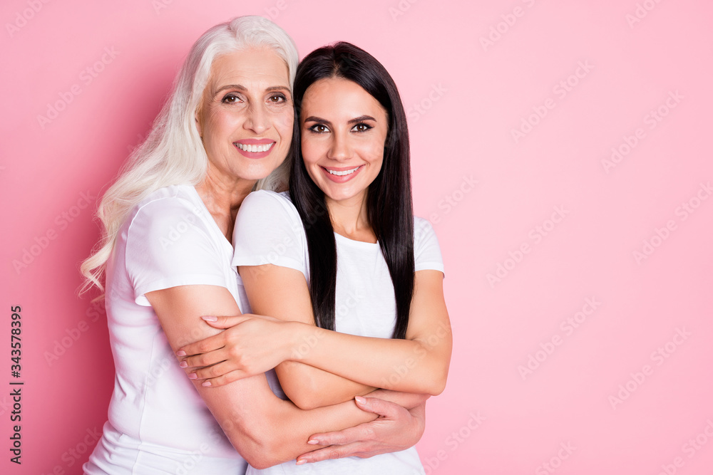 Portrait of two nice attractive lovely charming pretty cute sweet adorable gentle cheerful cheery women embracing cuddling isolated over pink pastel color background Portrait of two nice attractive lovely charming pretty cute sweet adorable gentle cheerful cheery women embracing cuddling isolated over pink pastel color background