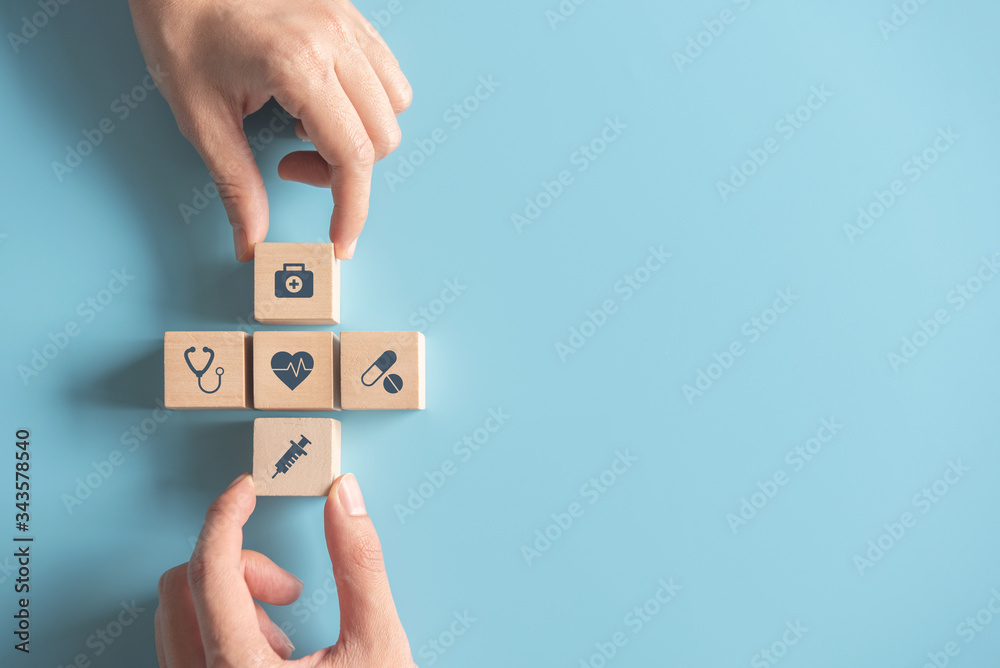 Health medical Insurance Concept, Two Hands arranging wood cube with  medical symbol on pastel blue background, copy space. Photos | Adobe Stock