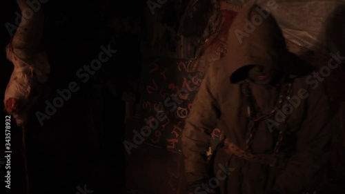 Silhouette of man maniac or killer or horror murderer with chainsaw in hand in dark creepy and spooky room. Criminal robber or rapist concept in thriller atmosphere with  victim girl